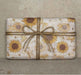 Clay & Colour Gift Wrap - Packaged product with sunflower design and twine bow on a textured background