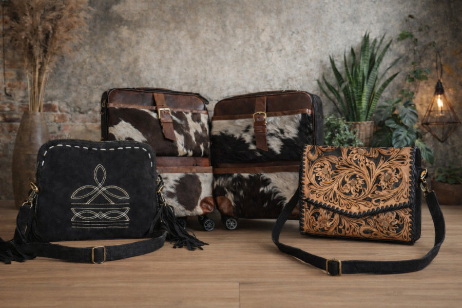Three leather handbags with intricate designs on a wooden surface.
